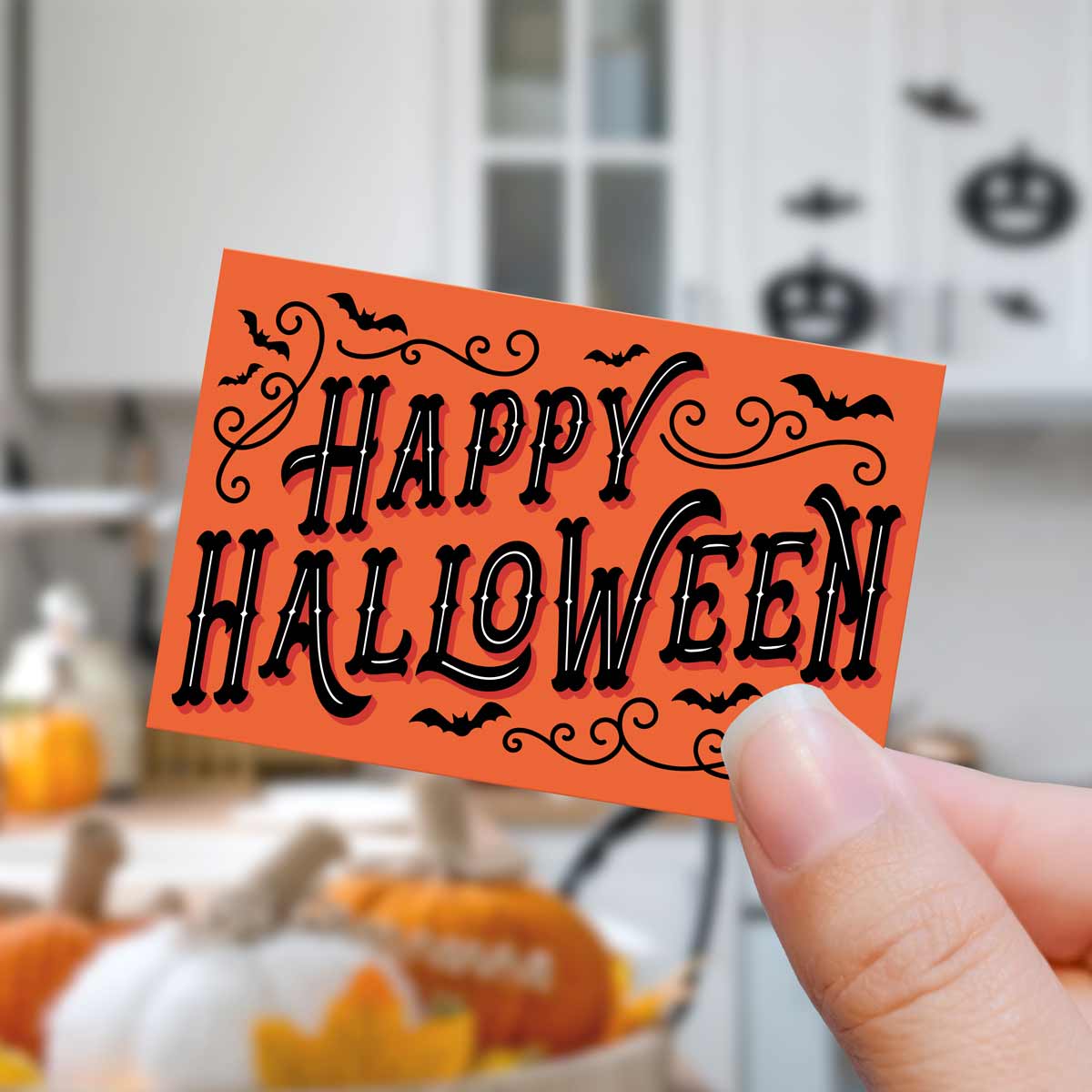 Hand holding a 'Happy Halloween' tag for cookie decorating